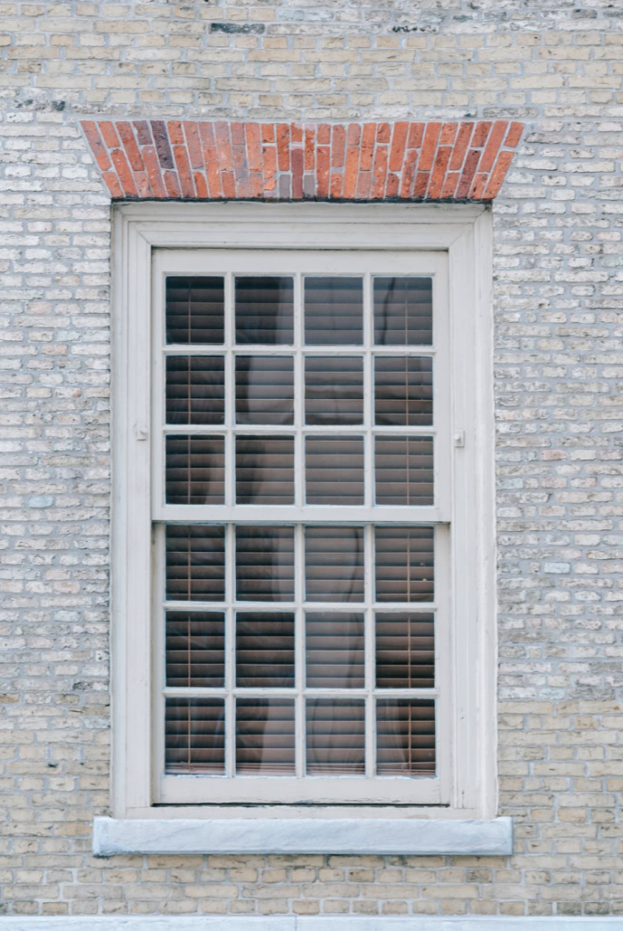 A window with a small ledge and brickwork wall.