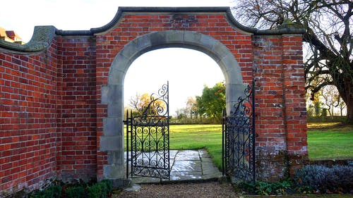 a black metal gate installed under an arched gateway