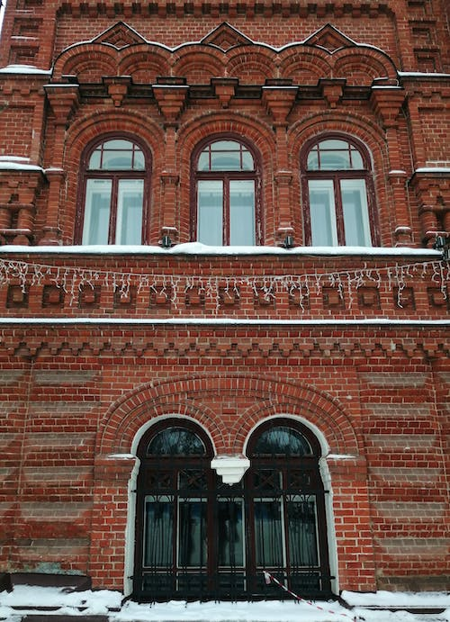 red brick walls with curved windows and arched doors