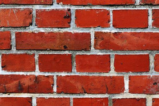 a wall made up of red bricks with a white mortar to hold the bricks together