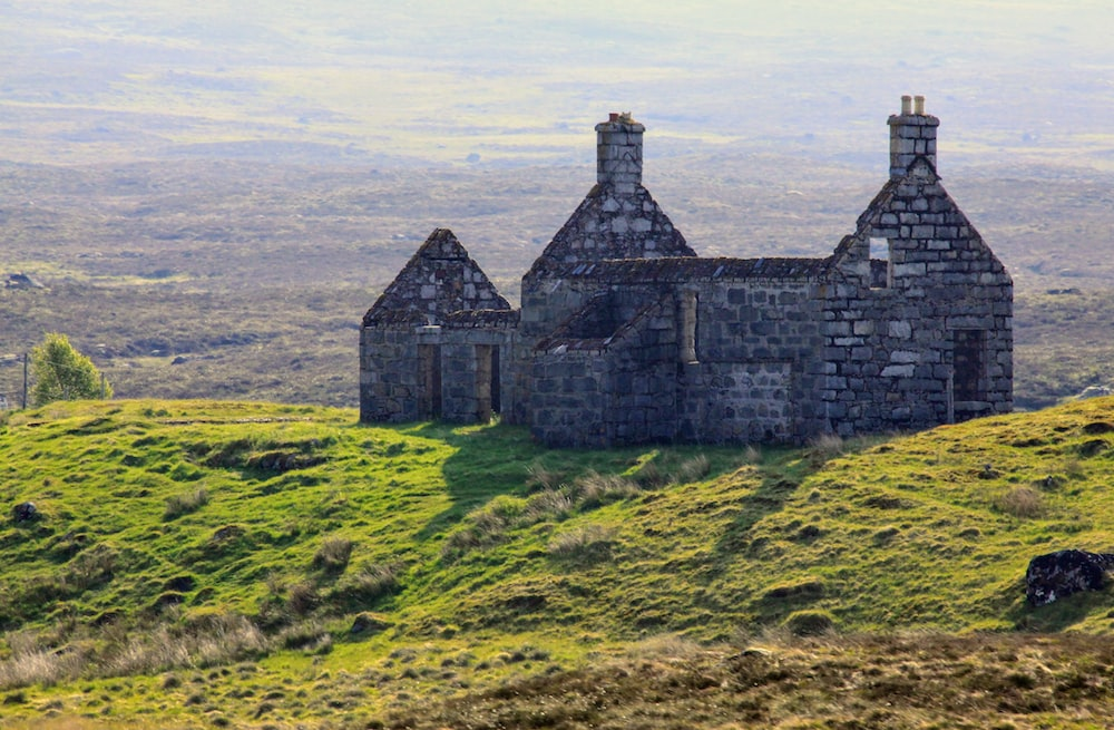 : a stone house made one top of a hill