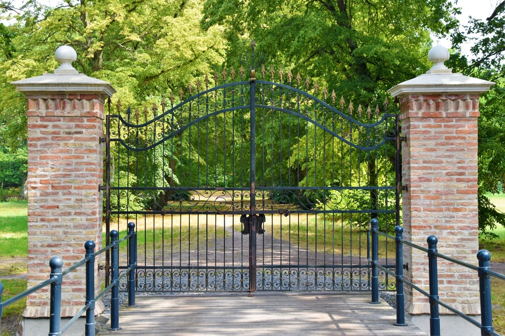 a classic metal gate installed in a long driveway
