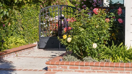 a classic black gate installed beside a front garden