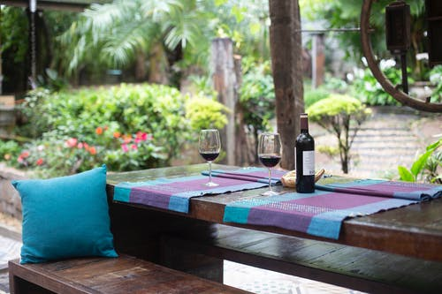 a bottle of wine on a garden table